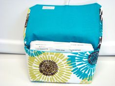 a blue and yellow flowered bag sitting on top of a white counter next to a wall