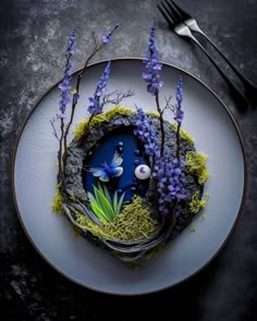 a white plate topped with purple flowers and moss