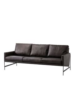 a black leather couch sitting on top of a white wall