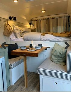 the interior of a camper with two beds and a table in front of it