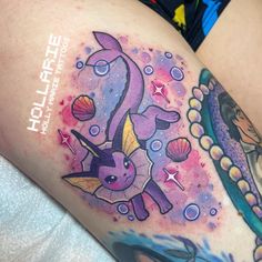 a woman's thigh with tattoos on it and an image of a cartoon character