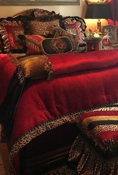 a bedroom with red bedding and leopard print pillows