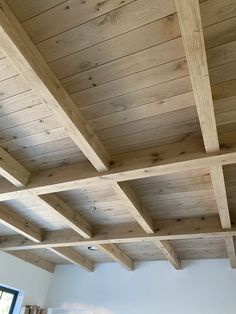 an unfinished ceiling with wooden beams in a living room