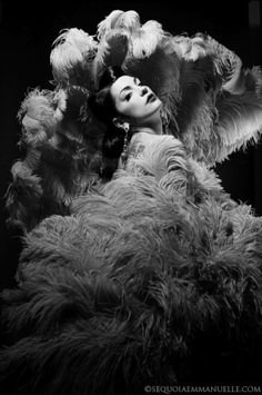 a black and white photo of a woman dressed in an ostrich costume with feathers