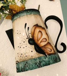 a lamp shade with a butterfly painted on it next to some flowers and a clock