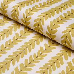 a yellow and white fabric with leaves on it