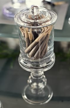 a glass container filled with cinnamon sticks on top of a table