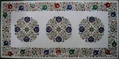 an intricately designed wall hanging with three circular medallions on the side and floral designs