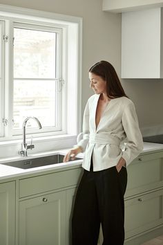 a woman standing in front of a kitchen sink