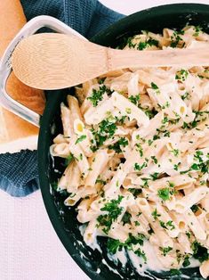 a pasta dish with chicken and parsley in a black skillet on a blue towel