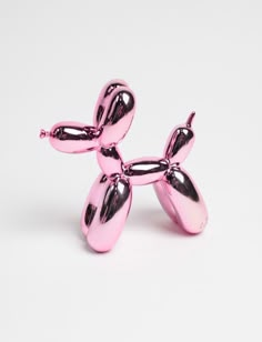 a pink balloon dog sitting on top of a white table