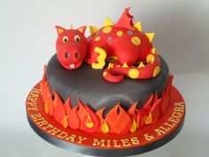 a birthday cake with a red and yellow dragon sitting on it's side in front of a white background