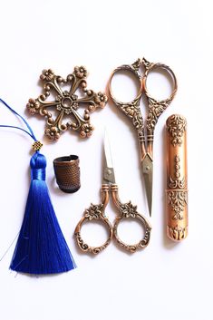 several different types of scissors and other items on a white surface with one being used as a keychain