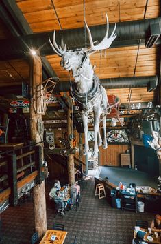 an animal statue hanging from the ceiling in a room filled with furniture and other items