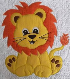 a quilted wall hanging with a lion on it's face and paw in the middle