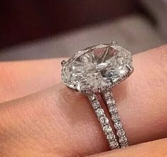 a close up of a person's hand with a diamond ring on their finger