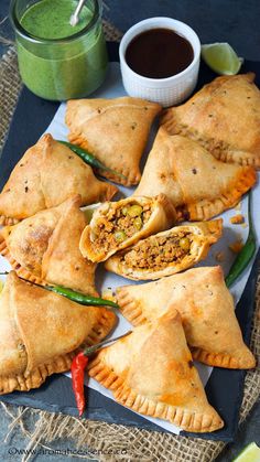 several empanada pastries on a plate next to a cup of green smoothie