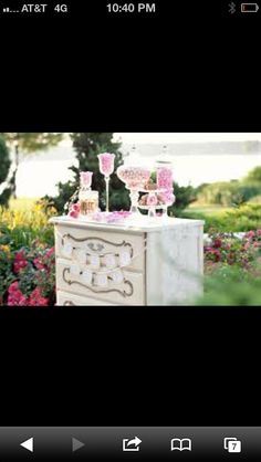 an image of a table with cake on it and pink flowers in the back ground