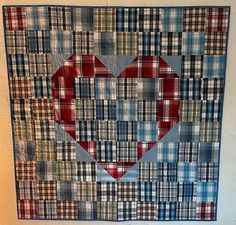 a quilt with a heart made out of plaid fabric on the front and back side