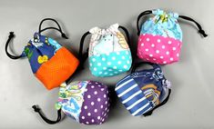 several small bags are lined up together on the floor with polka dots and colorful designs