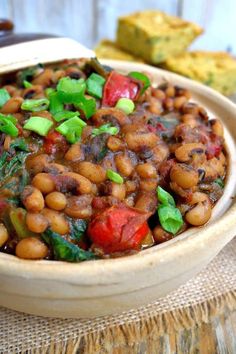 a bowl filled with beans and vegetables on top of a table