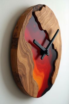 a wooden clock with red and orange designs on it's face, hanging from the wall