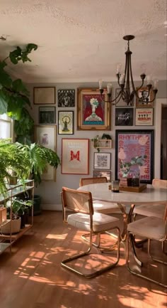 a dining room table with chairs and pictures on the wall in front of it's windows