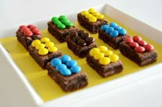 there are brownies with candy in the middle on a yellow paper towel that is sitting on a white plate