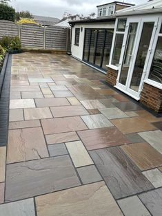 an outdoor patio with stone pavers and sliding glass doors