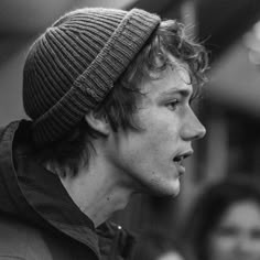 black and white photograph of a young man in a beanie looking off to the side