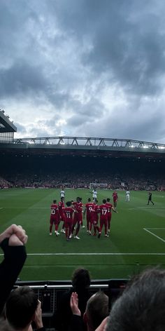 a group of people standing on top of a soccer field