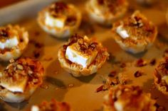 small appetizers sitting on top of a pan covered in sauce and marshmallows