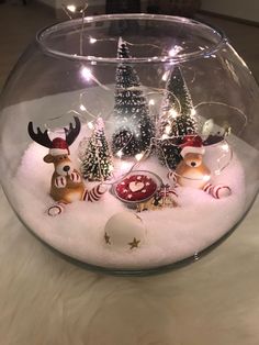 a glass bowl filled with snow and christmas decorations