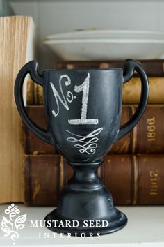 a black cup sitting on top of a table next to books