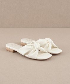 20% off at https://lithologieco.com/collections/shoes/products/kori-knot-flat-sandals-off-white Designed for a stylish minimalist, these knotted sandals are a versatile addition to any wardrobe. Heel Height: 0.75" Type of Closure: Slip On Upper Material: Vegan Leather Upper Insole Material: Padded Insole Hoco Shoes Flats, Beach Heels, White Sandals Flat, White Flat Sandals, Sandal Slippers, Random Products, Greece Trip, Womens Sandals Summer, Wedding 2024