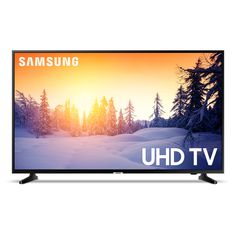 the samsung uhd tv is shown in front of a snowy landscape with trees on it