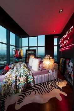 a living room with a zebra rug and large windows overlooking the city at night time