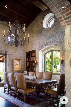 a dining room table with chairs and a chandelier hanging from it's ceiling