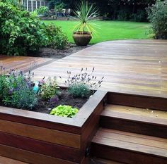 a wooden deck surrounded by plants and trees