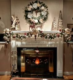 a fireplace decorated with christmas decorations and wreaths