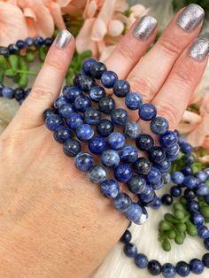 Blue sodalite bracelets with a mixture of blue hues, black and white veining that create an awesome finished look. The coloring on these is all natural and the stone comes from Brazil. Sodalite has tons of awesome properties that you can read about through the link below. These are an 8mm bead, so they are a bit chunkier. Great bracelet for anyone! You will receive ONE sodalite bracelet that is intuitively chosen for you.Approx Bead Size: 8mm Approx Size 6-6.5" around. Colors and bead size may v Blue Sodalite Hand-strung Bracelet, Hand-strung Blue Sodalite Bracelet, Blue Hand-strung Sodalite Bracelet, Blue Sodalite Bracelets For Gift, Sodalite Bracelet, Sodalite Jewelry, Blue Sodalite, Crystal Meanings, Blue Hues