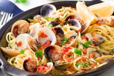 a skillet filled with pasta and clams