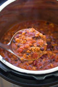 a spoon full of chili and beans in an instant pot