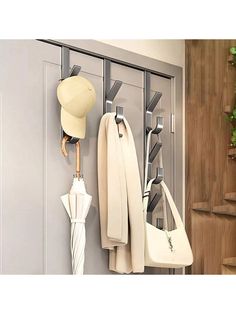 there is a coat rack with umbrellas and hats hanging from it's hooks