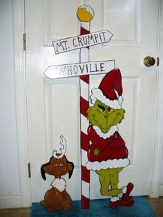 the grinch is standing next to a sign that says mt crumpit, y'hovillee