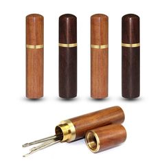 three wooden pepper grinders with brass trimmings and one is made out of wood