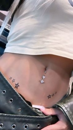 a woman's stomach with stars tattoo on her lower body and the bottom part of her stomach