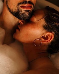 a man and woman are in the bathtub with foamy bubbles on their heads