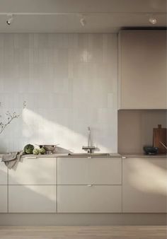 a modern kitchen with white cabinets and counter tops is pictured in this image from the front view