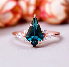 a green ring with white diamonds on it and an orange flower in the back ground